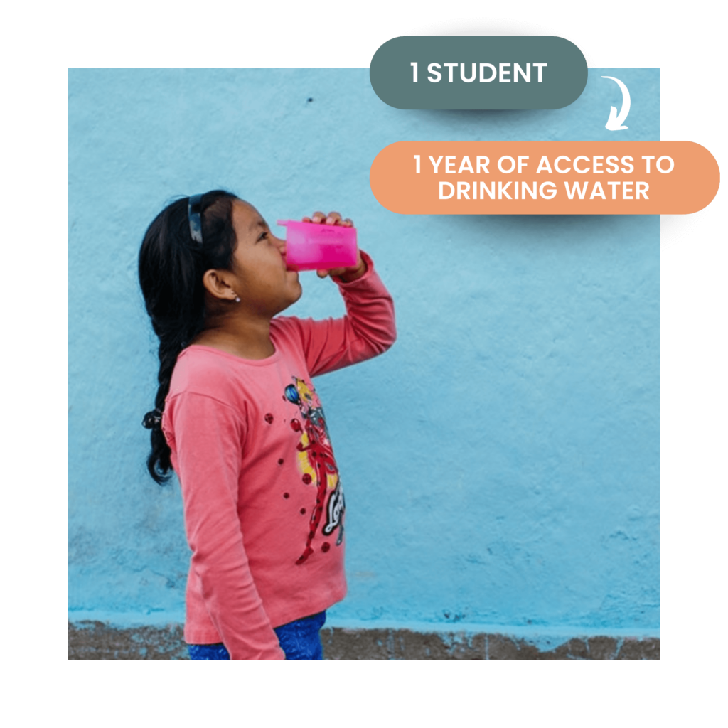 Little girl drinking water from a bright pink plastic cup. Speach bubbles on the upper right corner say 1 student = 1 year of access to drinking water.